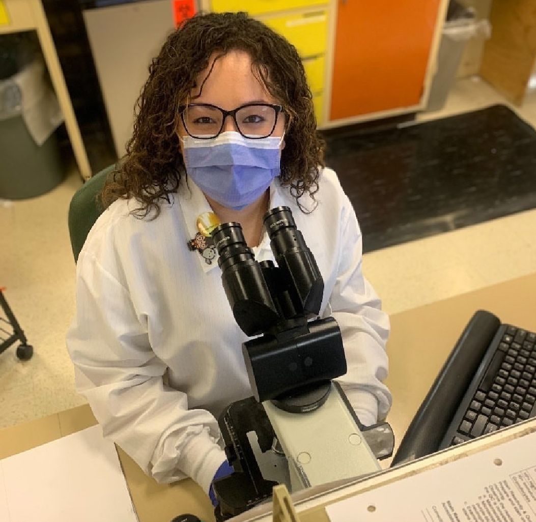 Alumna healthcare working wearing mask at research lab.