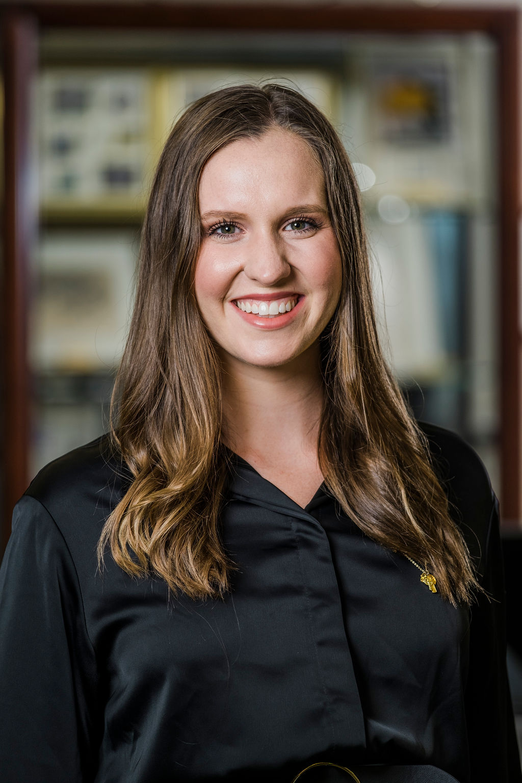Headshot of Cassidy Nulty in front of book cases displaying Sorority archives.