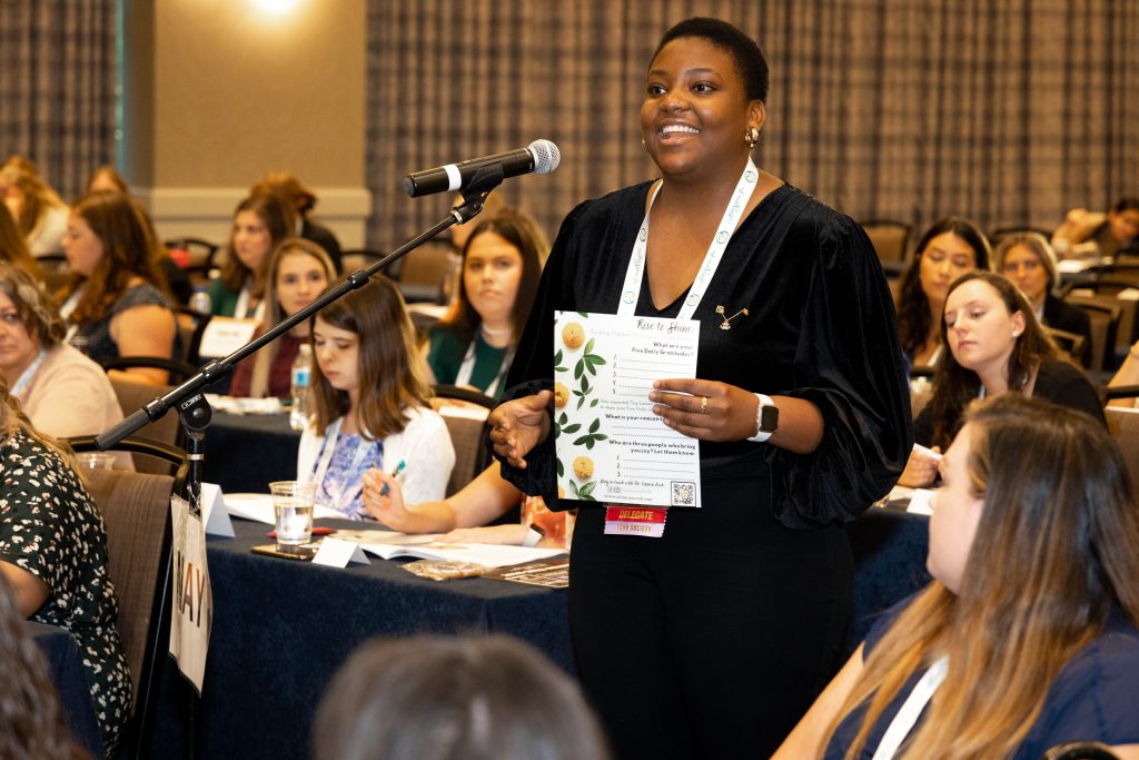 Alpha Sigma Tau Collegiate Member speaks into a microphone during an education session at Convention
