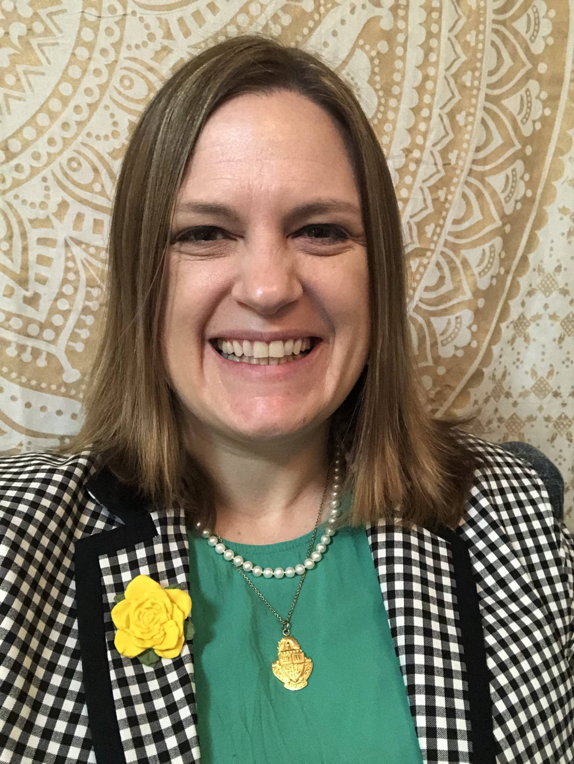 Headshot of Jenni Kemmery in front of book cases displaying Sorority archives.